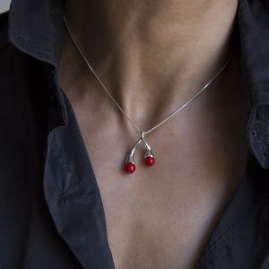 Colgante de plata 925 pulida, con esferas de 6mm de coral "bambú". Longitud total 4cm. Diseño inspirado en cuadro El Jardín de las Delicias (Museo del Prado, Madrid). En la simbología plasmada por el Bosco en esta obra, los frutos rojos representaron la tentación. Objeto diseñado y fabricado artesanalmente en Madrid por el estudio-taller de malicia.