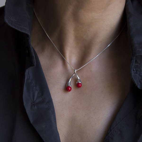 Colgante de plata 925 pulida, con esferas de 6mm de coral "bambú". Longitud total 4cm. Diseño inspirado en cuadro El Jardín de las Delicias (Museo del Prado, Madrid). En la simbología plasmada por el Bosco en esta obra, los frutos rojos representaron la tentación. Objeto diseñado y fabricado artesanalmente en Madrid por el estudio-taller de malicia.