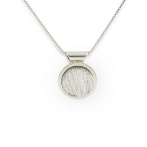 Colgante de plata 925 y piel de vacuno blanca, diámetro 15mm, grosor 4mm. Cadena de plata 925 tipo veneciana, longittud opcional 40cm, 45cm o 50cm. Objeto diseñado y fabricado artesanalmente en Madrid, España, por el estudio-taller de malicia. Este colgante ha sido fabricado por personas que disfrutan su trabajo
