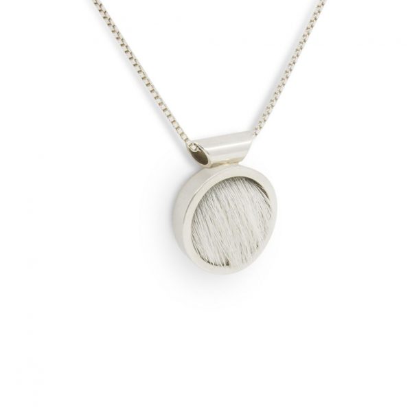 Colgante de plata 925 y piel de vacuno blanca, diámetro 15mm, grosor 4mm. Cadena de plata 925 tipo veneciana, longittud opcional 40cm, 45cm o 50cm. Objeto diseñado y fabricado artesanalmente en Madrid, España, por el estudio-taller de malicia. Este colgante ha sido fabricado por personas que disfrutan su trabajo