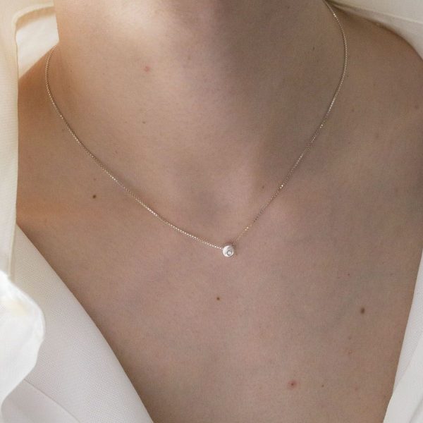 Gargantilla con colgante de plata 925 de 5mm de diámetro, y circonita talla brillante de 2mm. Cadena de plata 925, longitud opcional 40, 45 o 50cm. Cierre de "reasa" pequeña. Objeto diseñado y fabricado artesanalmente en Madrid, España, por el estudio-taller de malicia. Este anillo ha sido fabricado por personas que disfrutan su trabajo.