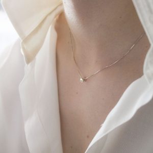 Gargantilla con colgante de plata 925 de 5mm de diámetro, y circonita talla brillante de 2mm. Cadena de plata 925, longitud opcional 40, 45 o 50cm. Cierre de "reasa" pequeña. Objeto diseñado y fabricado artesanalmente en Madrid, España, por el estudio-taller de malicia. Este anillo ha sido fabricado por personas que disfrutan su trabajo.