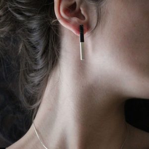 Pendientes de plata 925 mate con incrustación de madera de ébano. Longitud aprox. 45mm. Cierres de presión tipo "mariposa" de 6mm, de plata 925. Objeto diseñado y fabricado artesanalmente en Madrid, España, por el estudio-taller de malicia. Estos pendientes han sido fabricados por personas que disfrutan su trabajo.