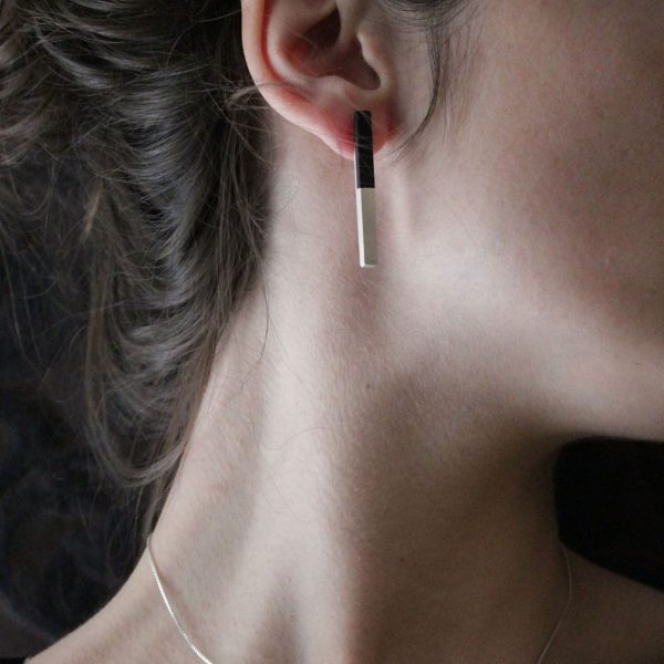 Pendientes de plata 925 mate con incrustación de madera de ébano. Longitud aprox. 45mm. Cierres de presión tipo "mariposa" de 6mm, de plata 925. Objeto diseñado y fabricado artesanalmente en Madrid, España, por el estudio-taller de malicia. Estos pendientes han sido fabricados por personas que disfrutan su trabajo.