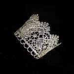 Pieza única diseñada y fabricada artesanalmente por el estudio-taller de malicia. Plata 925 envejecida. Objeto fabricado por personas que disfrutan su trabajo. En 2016, con motivo 400 aniversario del fallecimiento de Miguel de Cervantes y Saavedra, el estudio-taller edita una serie de piezas de joyería inspiradas en la figura del literato, la estética de su tiempo, y su obra más universal, El Quijote. Esta pieza construida íntegramente con plata 925, recrea aquellas puñetas bordadas que asomaban bajo las mangas del sobrio atuendo negro del típico hidalgo español del Renacimiento y Barroco. Esta estética en el vestir fue inmortalizada por el Greco en su “caballero de la mano en el pecho”, otrora considerado erróneamente un retrato de Cervantes.
