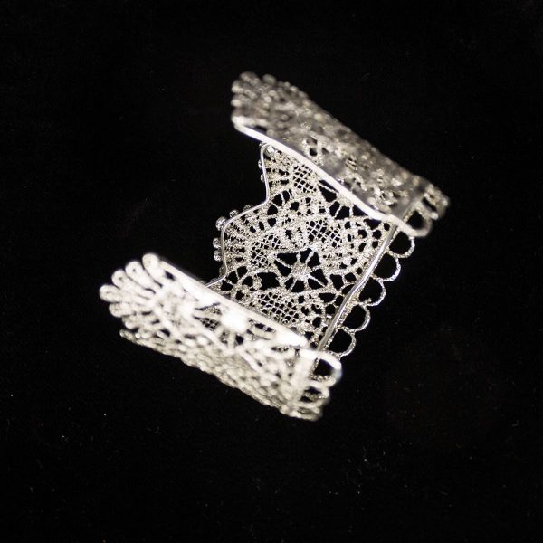 Pieza única diseñada y fabricada artesanalmente por el estudio-taller de malicia. Plata 925 envejecida. Objeto fabricado por personas que disfrutan su trabajo. En 2016, con motivo 400 aniversario del fallecimiento de Miguel de Cervantes y Saavedra, el estudio-taller edita una serie de piezas de joyería inspiradas en la figura del literato, la estética de su tiempo, y su obra más universal, El Quijote. Esta pieza construida íntegramente con plata 925, recrea aquellas puñetas bordadas que asomaban bajo las mangas del sobrio atuendo negro del típico hidalgo español del Renacimiento y Barroco. Esta estética en el vestir fue inmortalizada por el Greco en su “caballero de la mano en el pecho”, otrora considerado erróneamente un retrato de Cervantes.