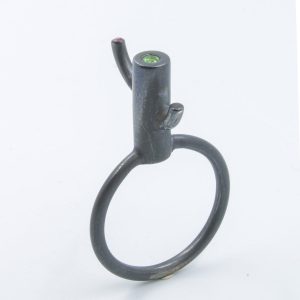 Anillo-colgante de plata ennegrecida con tsavorita (granate verde) y rubí. Se vende con cordón "cola de topo" trojo o negro, de 50cm. El diseño de esta serie de anillos-escultura hace referencia a la expresión española "irse por las ramas", que significa cambiar de tema deviando el discurso. Talla 18 Altura sobre el dedo 14mm Objeto diseñado y fabricado en Madrid por personas que disfrutan su trabajo, y celebran la riqueza de su lengua materna.